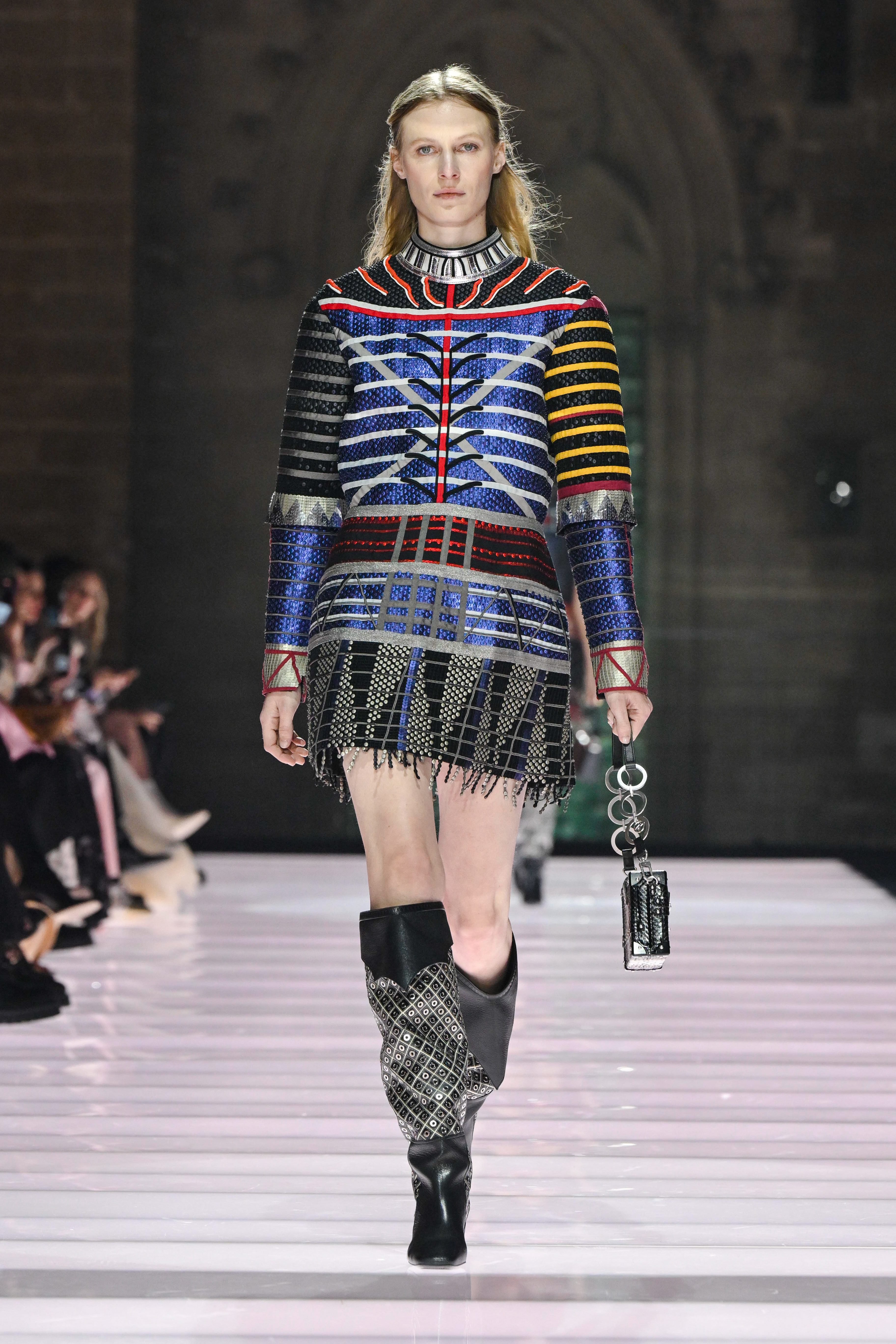 Model at the Louis Vuitton Cruise 2026 show wearing a patterned mini dress and boots.